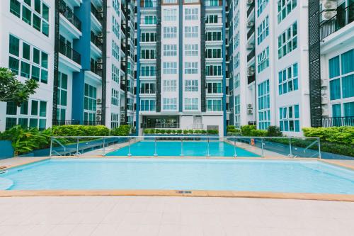an empty swimming pool in a building with tall buildings at Locals Prio ChiangMai Central Airport Plaza in Chiang Mai