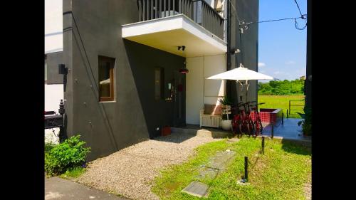 a building with a table and an umbrella on the side at Zebra Babala B&B in Dongshan