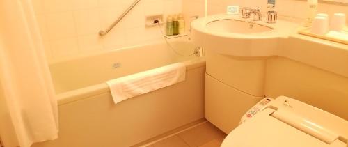 a small bathroom with a sink and a toilet at Hotel Grand Terrace Toyama in Toyama