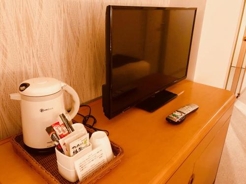 a table with a microwave and a television on it at Kanazawa New Grand Hotel Premier in Kanazawa