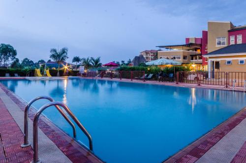 Una gran piscina con agua azul por la noche. en Las Vegas Garden Hotel, en Kampala