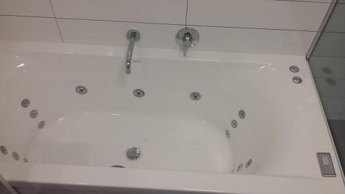 a bath tub with three faucets on top of it at Stopforths Motel in Hokitika