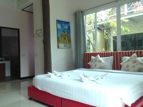 a bedroom with a large white bed with a window at Rao Ga Khao Resort in Mu Si