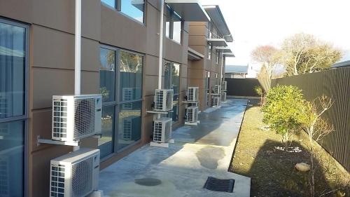 a row of air conditioners on the side of a building at Stopforths Motel in Hokitika