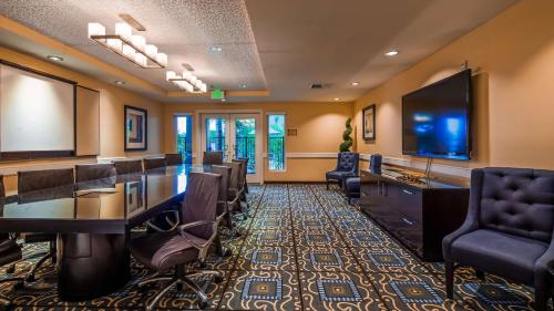 a conference room with a table and chairs and a flat screen tv at Best Western Plus Marina Gateway Hotel in National City