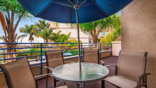 a table and chairs with an umbrella on a balcony at Best Western Plus Marina Gateway Hotel in National City