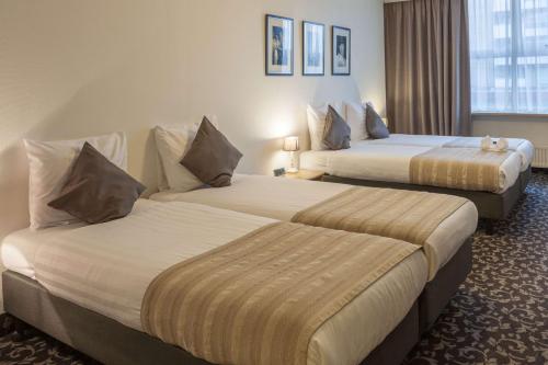 a hotel room with two beds in a room at Amsterdam Hotel Uithoorn in Uithoorn