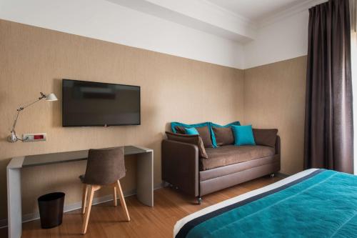 a living room with a couch and a television at Best Western Plus City Hotel in Genoa