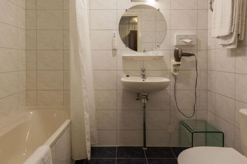 a bathroom with a sink and a toilet and a mirror at Amsterdam Hotel Uithoorn in Uithoorn