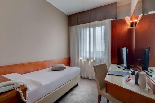 a bedroom with a bed and a desk with a computer at Best Western Hotel Turismo in San Martino Buon Albergo