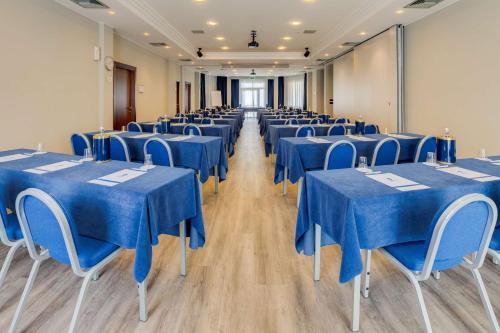 a row of tables and chairs in a room with blue table cloth at Best Western Hotel Turismo in San Martino Buon Albergo