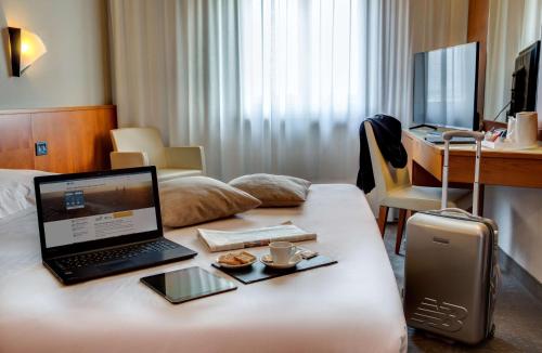 a laptop computer on a table in a hotel room at Best Western Hotel Turismo in San Martino Buon Albergo