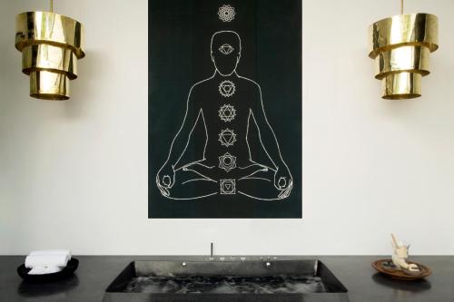 a painting of a man sitting in a yoga pose at The Secret Pool Villas By The Library Koh Samui in Chaweng