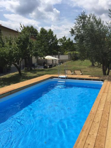 a swimming pool with blue water and a wooden deck at Sosta al Capitano in Pontassieve