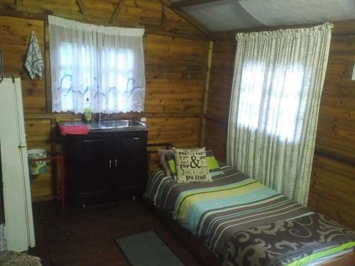 a bedroom with a bed and a sink in a cabin at Isikhoma-Khoma in Hilton