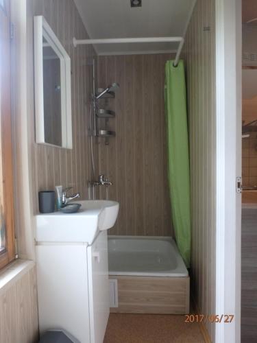 uma casa de banho com um lavatório, uma banheira e um chuveiro em Melluzi Cottage em Jūrmala