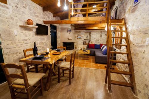 a dining room and living room with a loft bed at ARISTIDIS'S PLOUTI MOIRES in Ploutí