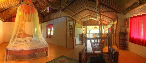 a bedroom with a bed in a room with a wooden ceiling at Bambua Nature Cottages in Puerto Princesa City