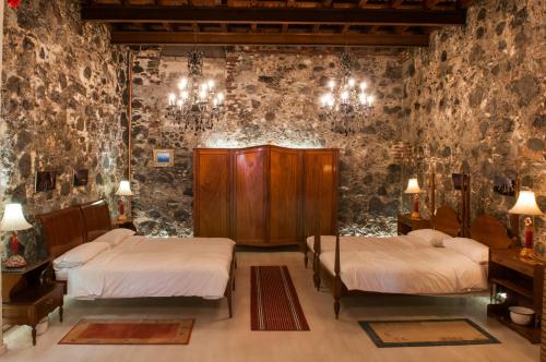 a room with two beds in a room with stone walls at Casa Amelia in Santa Cruz de la Palma