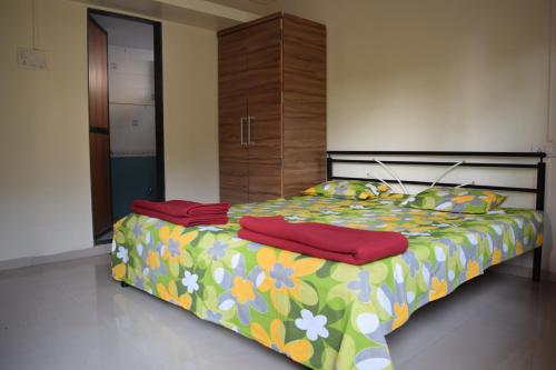 1 dormitorio con 1 cama con un edredón colorido en SWAMI home stay panhala, en Panhāla
