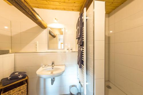 a white bathroom with a sink and a mirror at Schaumburger Schlafmütze in Rinteln