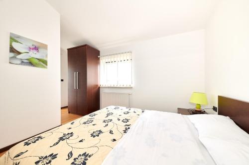 a bedroom with a bed with a floral bedspread at Ribarska Koliba - Stella Adria Villa in Pula