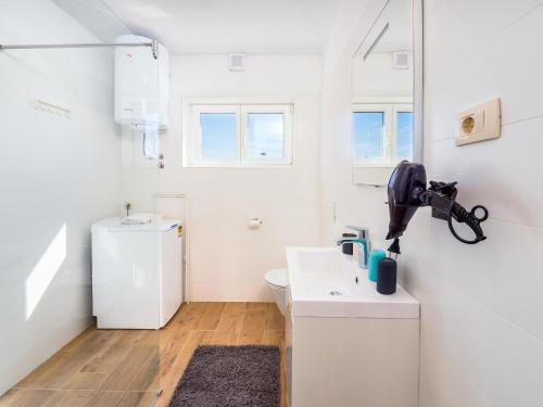 biała łazienka z umywalką i toaletą w obiekcie Appartments Adriatic w mieście Omišalj
