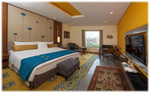 a bedroom with a large bed and a living room at Welcomhotel by ITC Hotels, Jodhpur in Jodhpur