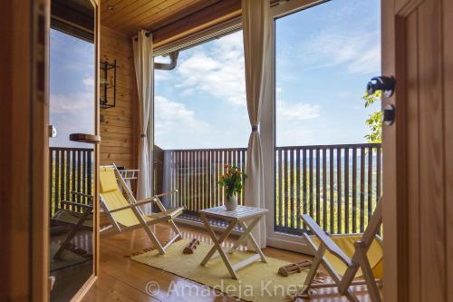 eine Veranda mit Stühlen und einem Tisch auf dem Balkon in der Unterkunft HERBALIJA Apartment Herbalija - sorrounded by Nature in Podčetrtek