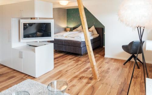 a bedroom with a bed and a tv in a room at Boutique Hotel Friesinger in Kressbronn am Bodensee