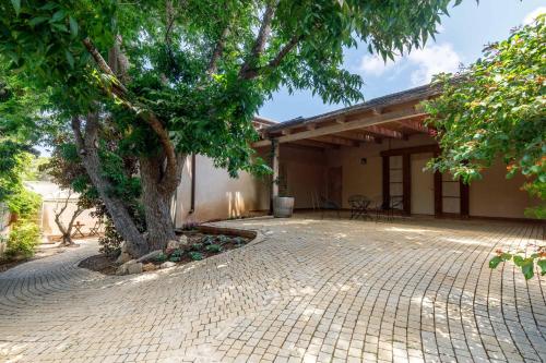a house with a tree in front of it at Smadar Inn in Zikhron Ya‘aqov