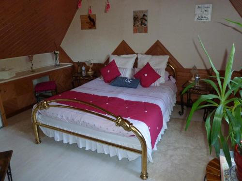 1 dormitorio con 1 cama con almohadas rojas en Les Alicourts, en Annebault