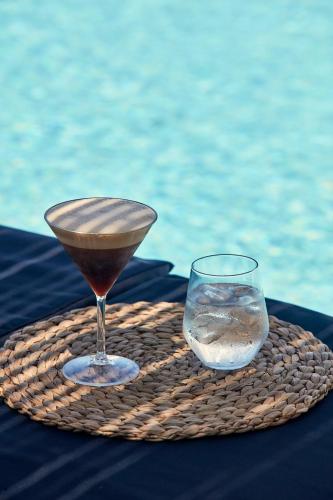 a glass of water sitting on a table near the water at Callia Retreat Suites - Adults Only in Fira