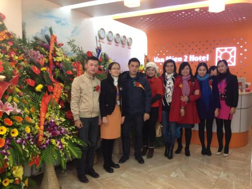 a group of people standing in front of flowers at Van Mieu 2 Hotel in Hanoi
