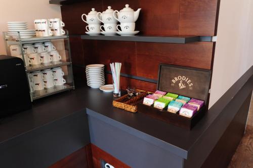 a black counter with a shelf with plates and bowls at Hotel Donauhof Mauthausen in Mauthausen