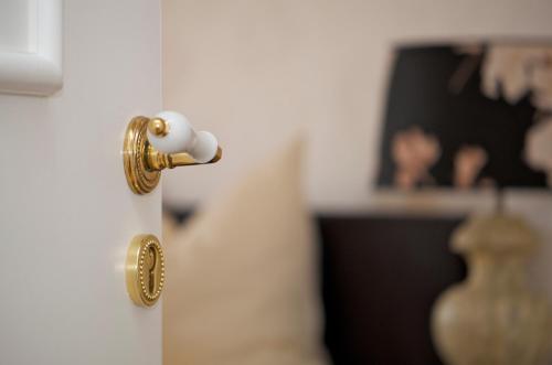 a gold door knob on a white door at Boutique Hotel Friesinger in Kressbronn am Bodensee