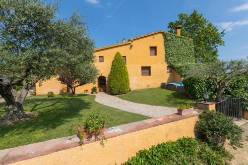 a large yellow house with trees and a yard at Turisme Rural Ca l,Anguila in Peratallada