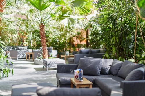 a living room with blue couches and palm trees at Tropical Islands in Krausnick