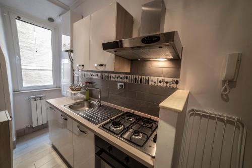 uma cozinha com um lavatório e um fogão forno superior em Galleria Frascati Rooms and Apartment em Frascati