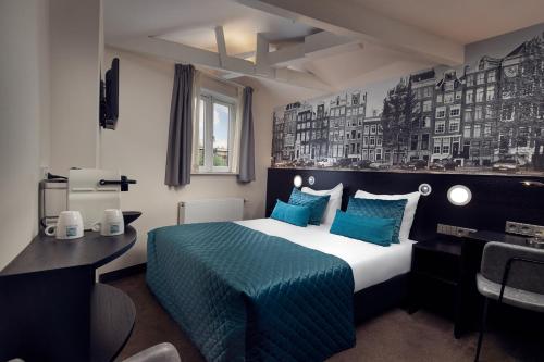 a hotel room with a large bed and a desk at Singel Hotel Amsterdam in Amsterdam