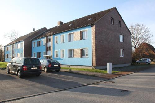a blue building with two cars parked in front of it at Haus Marinus in Puttgarden