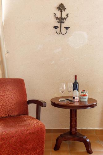 a table with two wine glasses and a chair at Smadar Inn in Zikhron Ya‘aqov