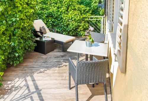 a patio with a table and chairs on a deck at Boutique Hotel Friesinger in Kressbronn am Bodensee