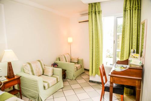 een woonkamer met 2 stoelen en een tafel bij Tchero Hotel in Douala