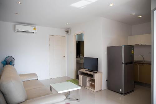 a living room with a couch and a refrigerator at Mosaic Condominium by Malai in Mae Pim