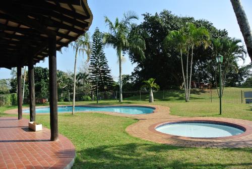 a swimming pool in a park with palm trees at 9 The Bridge Holiday Resort in St Lucia