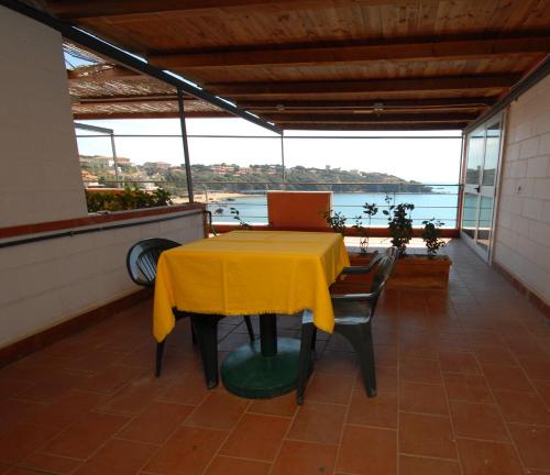 a table with a yellow table cloth on a balcony at Hotel Baia Del Sorriso in Castiglioncello