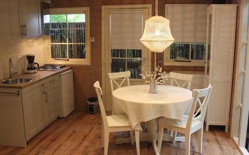 a kitchen with a white table and chairs and a chandelier at Mare Sanat in Wijk aan Zee