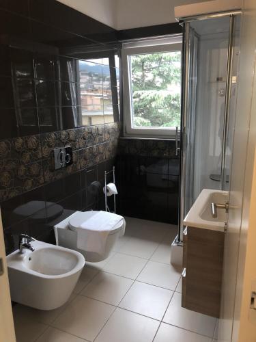 a bathroom with a sink and a toilet and a shower at Roggia Apartments by Quokka 360 - central flats with parking space in Lugano