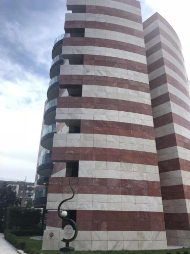 a tall building with red and white stripes on it at Roggia Apartments by Quokka 360 - central flats with parking space in Lugano